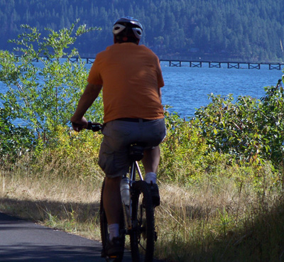 Cyclist along Lake Coeur d'Alene near Harrison, Idaho